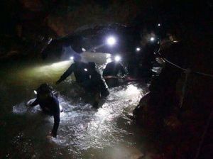 Rescue teams walk inside cave complex where 12 boys and their football coach went missing (Tham Luang Rescue Operation Center via AP)