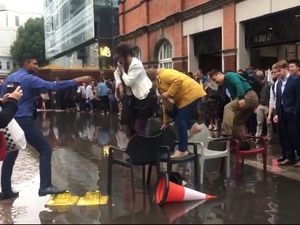 Supporting image for story: Watch: Londoners make bridge of chairs amid flooding at Hammersmith station
