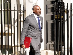David Lammy walking on 10 Downing Street carrying a red folder