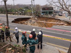 Rescuers inspect a sinkhole on a road in Seoul, South Korea