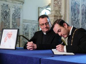 Belfast Lord Mayor Micky Murray (right) at Belfast City Hall with Father Tim Bartlett, signing a book of condolence