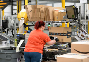 A member of staff packaging at item at the Amazon warehouse in Rugeley