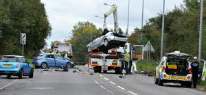 A damaged car is removed from the scene