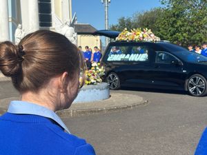A schoolgirl forms part of a guard of honour outside St Mary's Oratory in Buncrana ahead of the funeral of teenager Emmanuel Familola