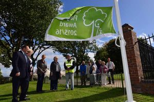 Dignitaries and supporters watch the flag being raised