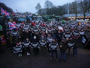 Farmers holding placards in front of their tractors at Belmont Farm in north London