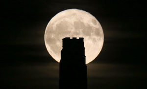 The Beaver Moon rises behind St Michael's Tower on the top of Glastonbury Tor in 2017.