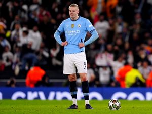 Erling Haaland stands with his hands on his hips