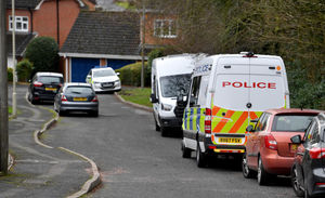 A number of police vans are visible on the road
