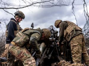 Ukrainian servicemen of Khartia brigade loading shell into M101 Howitzer before firing towards Russian positions in Kharkiv region, Ukraine