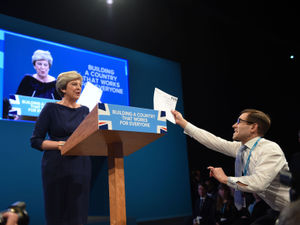 Supporting image for story: Coughs and a protest mar Theresa May's speech