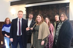 Lichfield District Council Leader Doug Pullen presents the key to The Schoolmaster’s House to Katie Gomez of Lichfield Discovered while fellow Lichfield Discovered volunteers (from left) Morwenna Rae, John Tanner, Teresa Gilmore, John Gallagher and Jacky Billingsley look on.