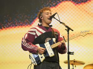 Sam Fender playing a black and white guitar