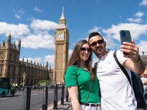 Tourists pose for a selfie with Elizabeth Tower and the Houses of Parliament