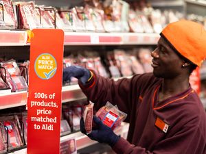 A Sainsbury's worker putting products on shelves