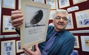 Derek John Nicholls, the man who put the exhibition together, holds a picture of a Zeppellin aircraft