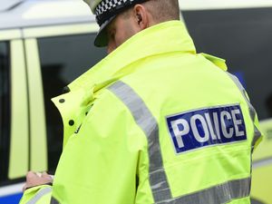 An unidentified police officer next to a police car