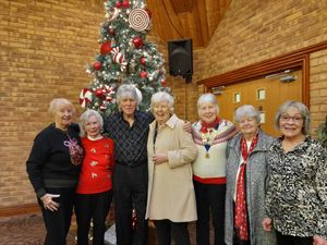 Members, including Pam Clarke (red jumper) having fun with David St John.