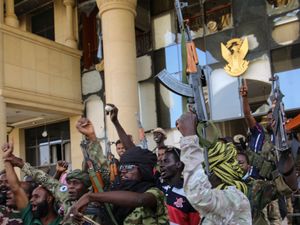 Soldiers celebrate after taking over the Republican Palace in Khartoum