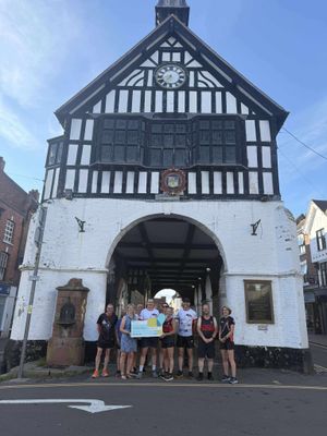 Bridgnorth Running Club's Chairperson, Dan Morris, and 10k Race Director, Vicky Morris, presenting the £2000 cheque to Nicky Green, Senior Community Fundraiser for Severn Hospice, accompanied by members of Bridgnorth Running Club.