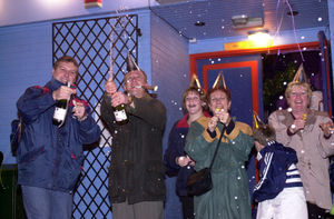 Gary Roberts from Newport (second left) cracks-open the champagne as the clock strikes midnight one new year's eve