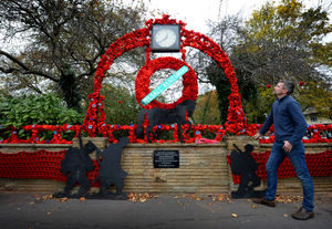 The clock in Pelsall centre, covered in knitted poppies in 2018. Pictured is Ian Page, who works at Pelsall Village Centre viewing the display