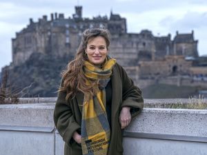 Nicola Benedetti smiling in front of Edinburgh Castle