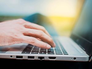 Close up of a person's hands on the laptop keyboard