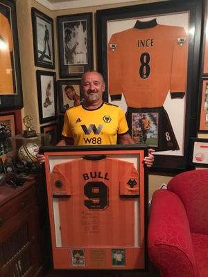 Nick in his Wolves man cave holding Bully’s 20-year anniversary shirt