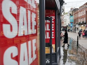 A shopper enters a store holding a sale