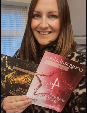 Katie proudly displaying her certificates from Slimming World 