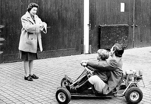 Prince Charles gives his five-year-old brother, Prince Edward, a ride on a go-kart in the grounds of Windsor Castle while the Queen watches on
