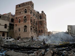 Locals inspect a site reportedly struck by US airstrikes overnight in Sanaa, Yemen