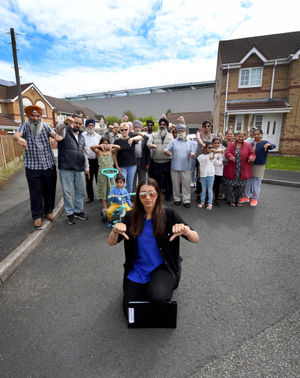 Karen Kang, front, and fellow residents give the thumbs down to the warehouse