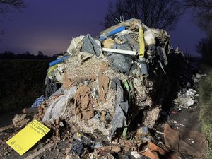 A pile of fly-tipped waste with a sign appealing for information