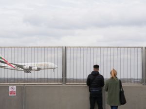 People watch an Emirates plane at Heathrow Airport in London