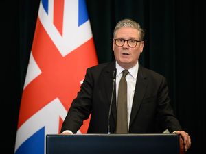 Sir Keir Starmer speaking from behind a lectern in front of a Union flag