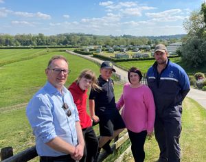 From left to right: Russell George MS, Frankie, Dougie, Sam and Ed Williams. The proposed route would be visible in the background from left to right, behind the holiday homes. Photo: Russell George MS
