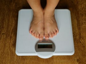 A young child is weighed on scales