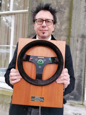 Hansons' auctioneer Rik Alexander with the Ayrton Senna steering wheel. Photo: Hansons