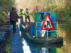 The work barge is pulled towards the towpath