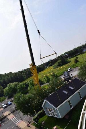 The bungalow being lifted into position by crane