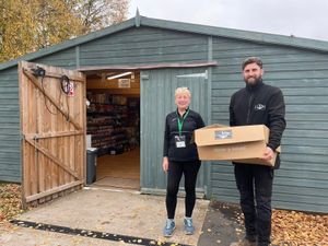 Dena Hill of Lichfield Foodbank receives a food donation from Cawarden site manager Callum Porter.