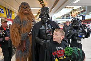 Darth Vader and Chewbacca use the force as people pose for photos