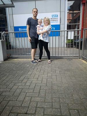 A family photo outside Birmingham Children's Hospital. Darren, Jade and Mabel