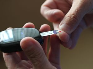 A diabetic man testing his blood glucose levels