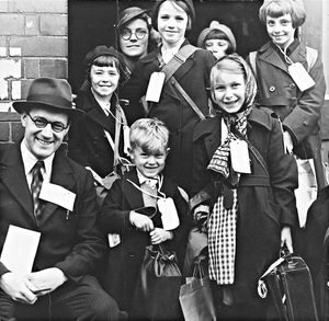The photograph shows six children evacuees from Smethwick, complete with labels and luggage, with the Clerk to Shifnal Council, Mr G. Thomas.