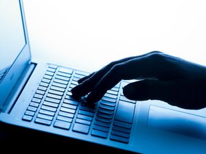 A woman’s hand pressing keys of a laptop keyboard