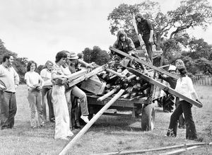 Volunteers at Attingham Park on July 12, 1974. The caption pasted on the back reads: 'Another day starts for a group of volunteers from all over the country who have been spending a week at Attingham Park, near Shrewsbury, working on the 1,000 acre National Trust estate. Left is Mr David Hilditch (estate foreman).' 