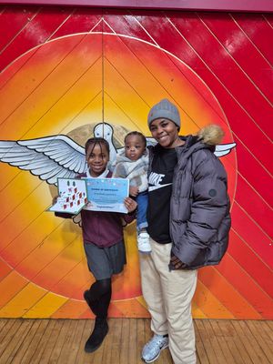 Deborah Chibueze, with mum Glory Chiubueze holding Deborah’s younger brother, holds her card and certificate